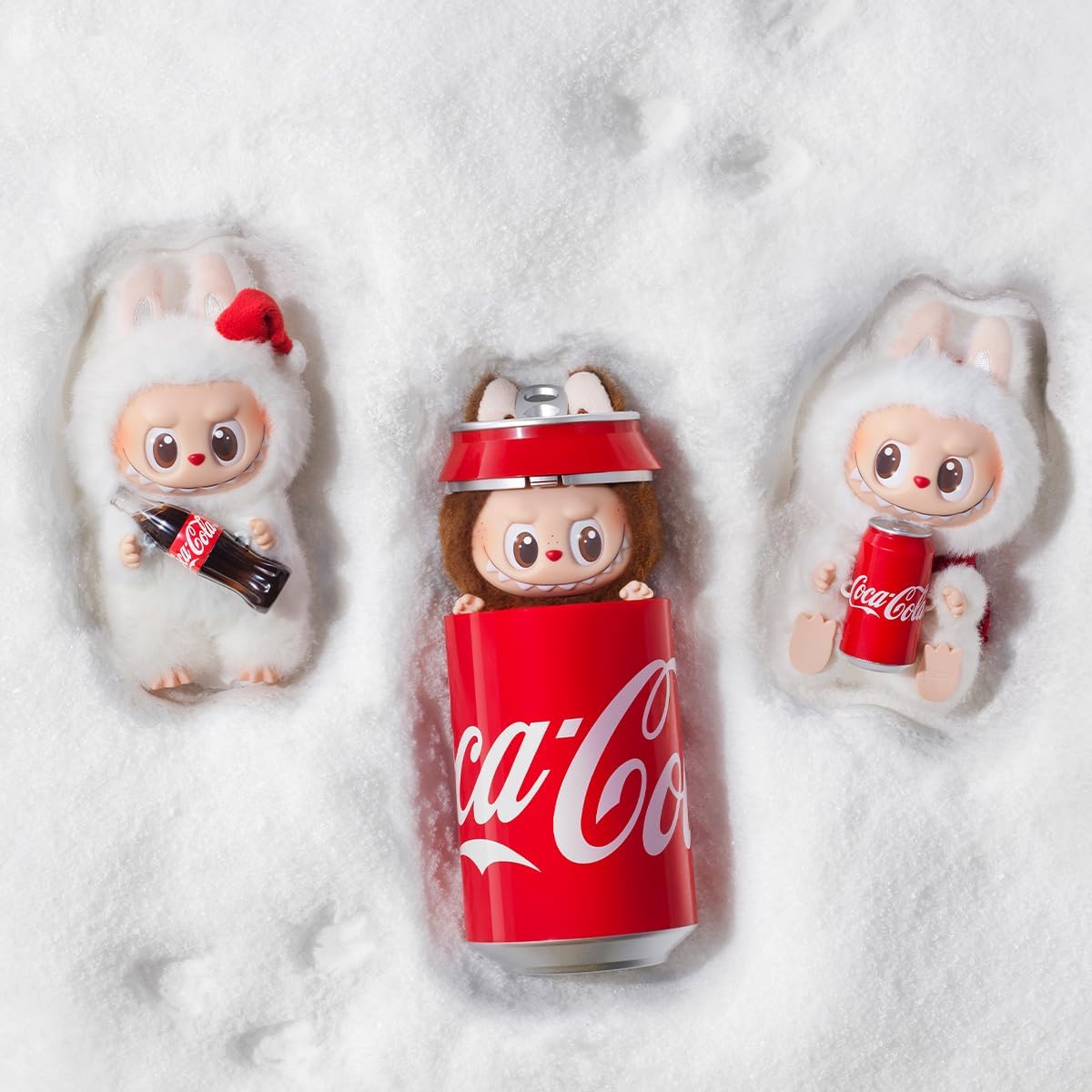 POP MART THE MONSTERS Coca-Cola series figures shown in the snow with a Coca-Cola can