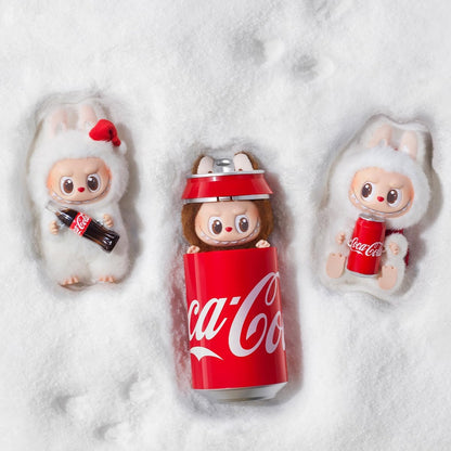 POP MART THE MONSTERS Coca-Cola series figures shown in the snow with a Coca-Cola can